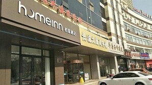 A hotel with a 'homeinn' sign, a visible entrance, and a parked car. - Home Inn Hotel Beijing Miyun Changchenghuandao (Miyun)