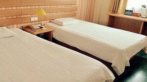 A hotel room with two single beds, a wooden headboard, a bedside table with a lamp, and a window with curtains. - Home Inn Hotel Beijing Miyun Changchenghuandao (Miyun)