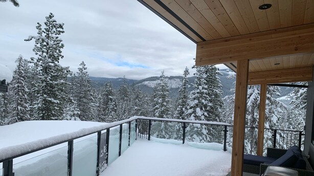 A wooden deck with a glass balustrade overlooking a snowy mountain landscape. - The Treehouse Suite with a roof top jacuzzi hot tub. Private and Quiet. (Bonnington Falls)
