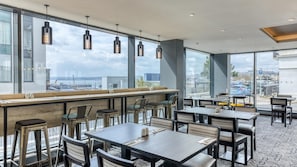 A restaurant with large windows, multiple tables, and chairs. - Premier Inn Torquay Harbour (Torquay)