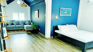 A modern bedroom with a bed, a sofa, and a large window.