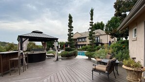 A wooden deck with outdoor furniture, a covered seating area, and a swimming pool. - Serene Guest House on Avocado Grove and Vineyard (Fallbrook)