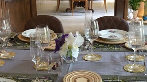 A dining area with a table set for a meal, featuring plates, cutlery, and glasses. - Self-contained apartment in a magnificent estate (Romans-sur-Isère)