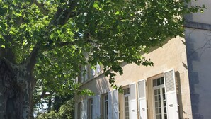 A building with a covered porch, potted plants, and a pathway leading to the entrance. - Self-contained apartment in a magnificent estate (Romans-sur-Isère)