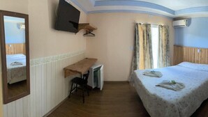 A bedroom with a bunk bed, a desk, a chair, and a television mounted on the wall. - Pousada Primavera Campos do Jordão (Campos do Jordão)