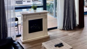 A modern living room with a fireplace, large windows, and a view of the cityscape. - AMERICA LUXURY EXTENDED STAY (Lagos)