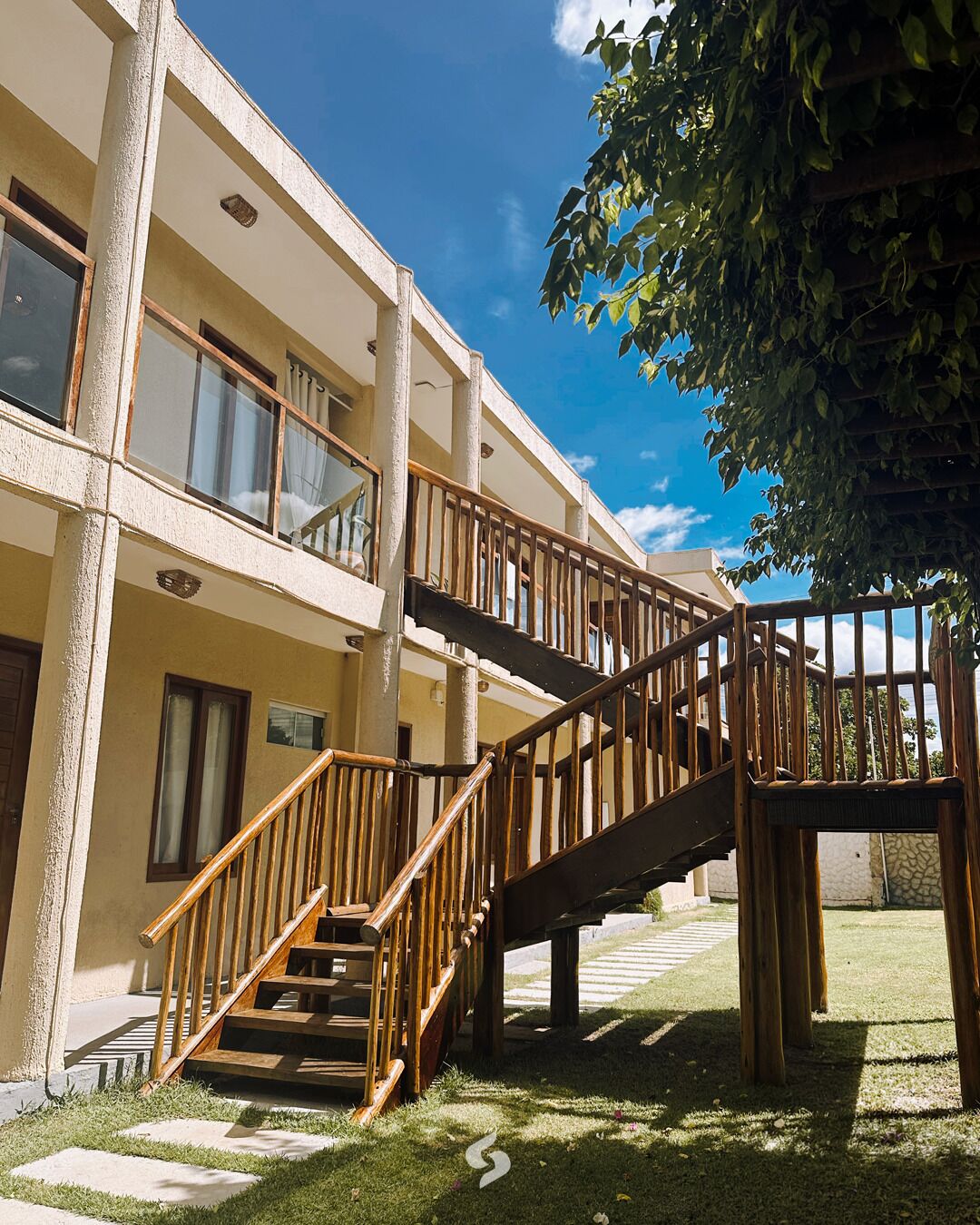 Un immeuble à plusieurs étages avec un escalier en bois menant à un balcon.