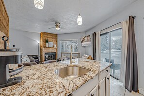 A modern kitchen with a large island, built-in oven, and a large window with curtains. - Cozy, Lake View Condo in Hidden Valley with Ski Slope Access  (Hidden Valley)