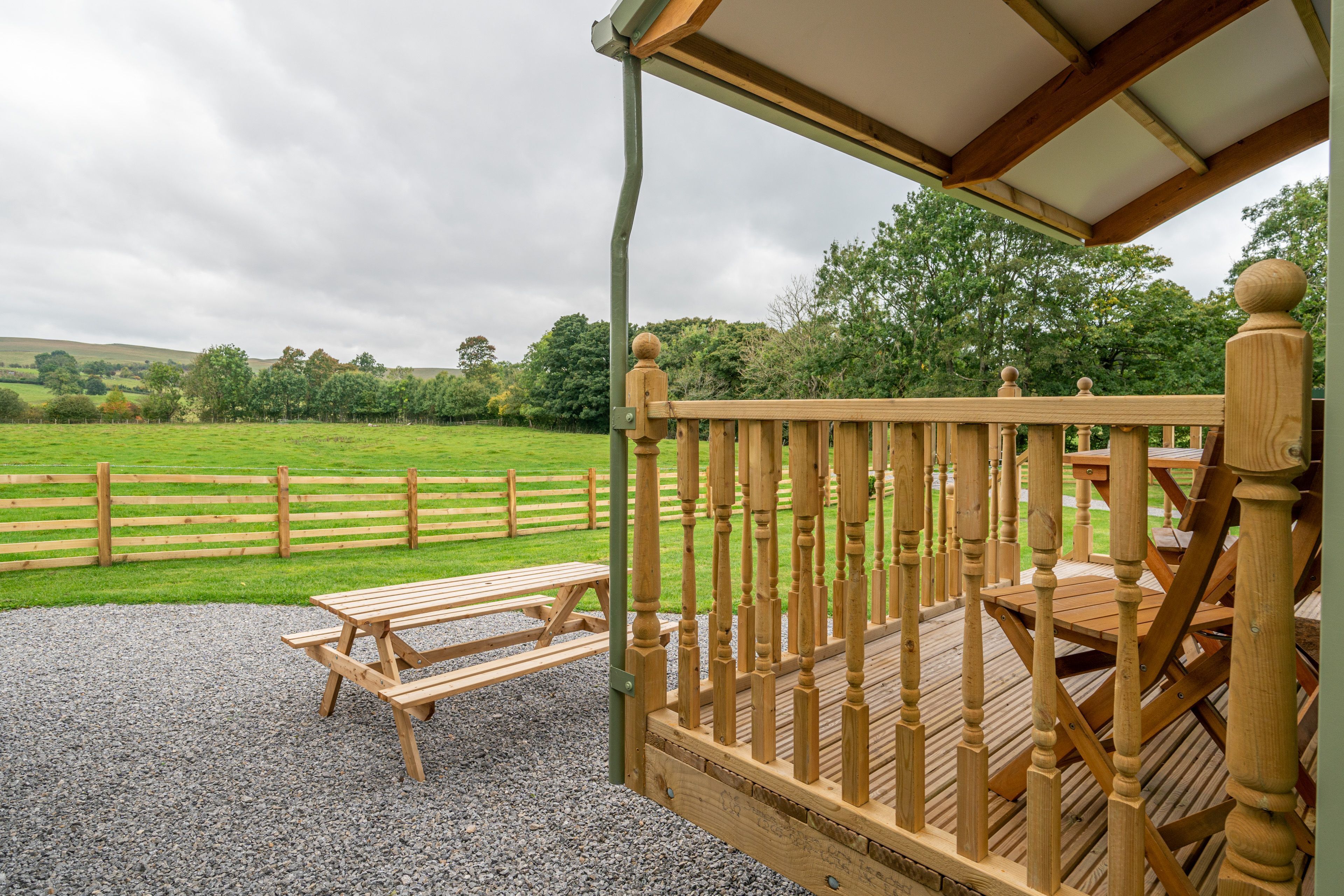 A wooden deck with a picnic table and a covered seating area.