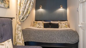 A bedroom with a bed, curtains, and two wall-mounted lights. - Low Nook Cottage -  Newly refurbished cottage for three guests (Broughton-in-Furness)