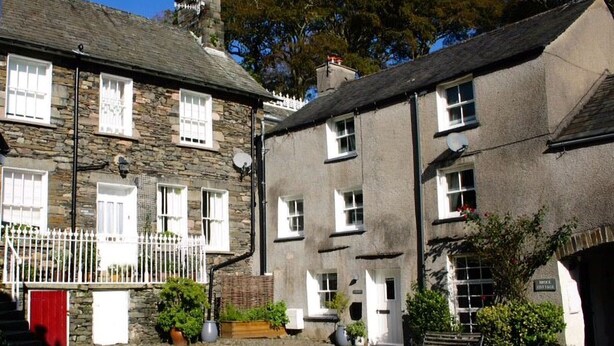 A traditional stone building with multiple windows and a white fence. - Low Nook Cottage -  Newly refurbished cottage for three guests (Broughton-in-Furness)