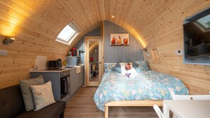 A cozy cabin with a loft-style bedroom, a kitchenette, and a dining area.