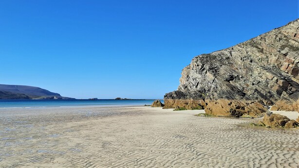 A beach with clear blue water, sandy shore, and rocky cliffs. - Sangobeag -  a cottage that sleeps 6 guests  in 3 bedrooms (Durness)