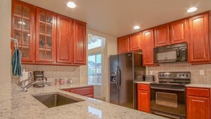 A kitchen with granite countertops, stainless steel appliances, and wooden cabinets. - Bright and Spacious Home in Quiet Neighborhood - ASTRP260664 (Colorado Springs)