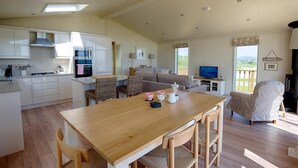 Un vaste espace de vie comprenant une table à manger en bois, un canapé et un téléviseur.