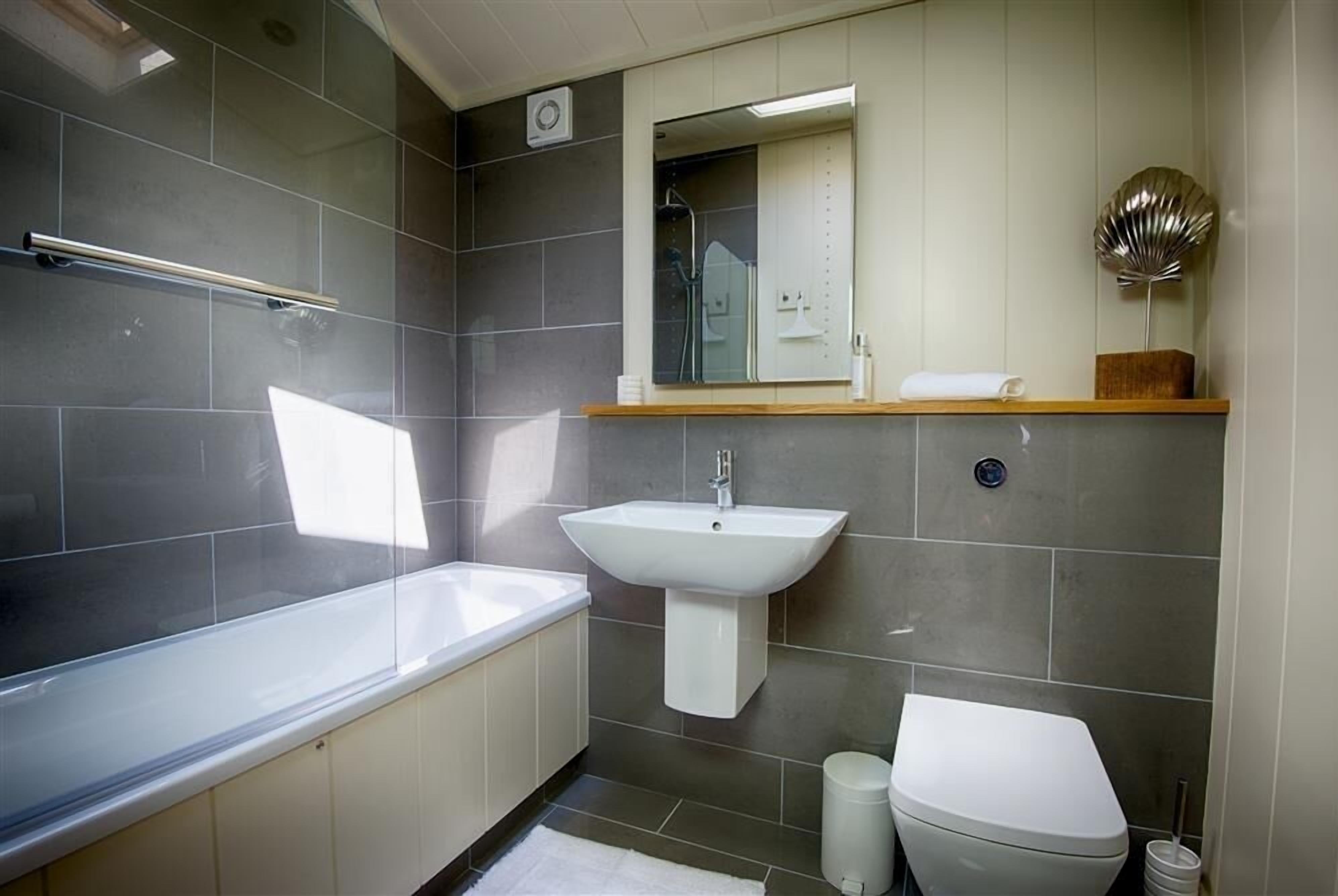 Ein modernes Badezimmer mit Badewanne, Waschbecken und Toilette.