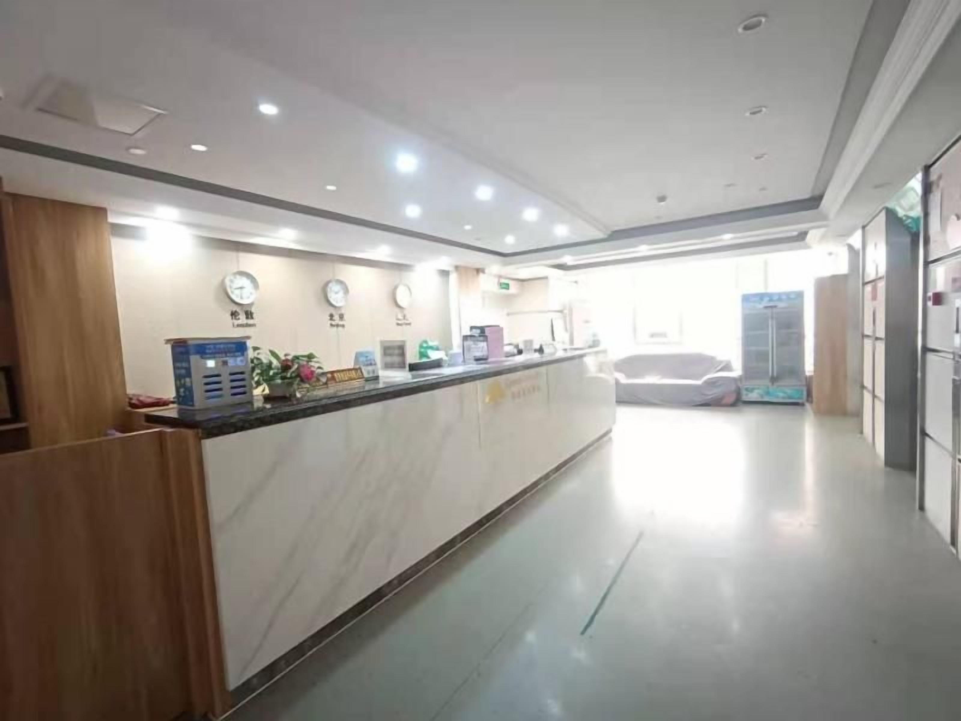 A reception area with a marble counter, clocks, and a car in the background.