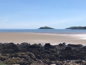A beach with rocky foreground and calm sea.