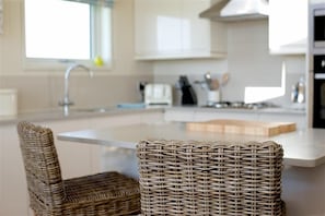 A kitchen with a central island, a sink, and a chair. - Granary Lodge -  a lodge that sleeps 6 guests  in 3 bedrooms (Gatehouse of Fleet)