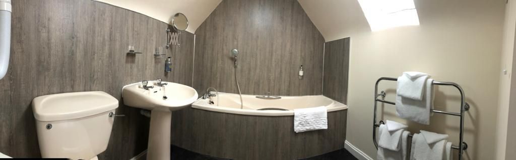 A bathroom with a toilet, sink, and bathtub.