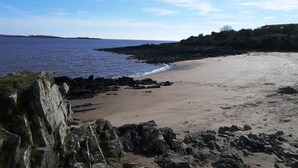 A beach with rocky shoreline and a clear sky. - Threaby Cottage -  a cottage that sleeps 4 guests  in 2 bedrooms (Gatehouse of Fleet)