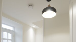 Un couloir avec un sol à motifs, un escalier et une porte dotée d’une fenêtre.