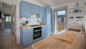 A modern kitchen with blue cabinets, a wooden countertop, and a built-in oven.