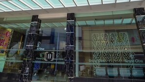 A modern building with multiple floors, large glass windows, and a prominent entrance with a red carpet. - Grand Citra Hotel Makassar By Life (Makassar)