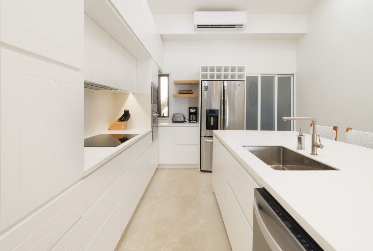 A modern kitchen with white cabinetry, stainless steel appliances, and a dishwasher.