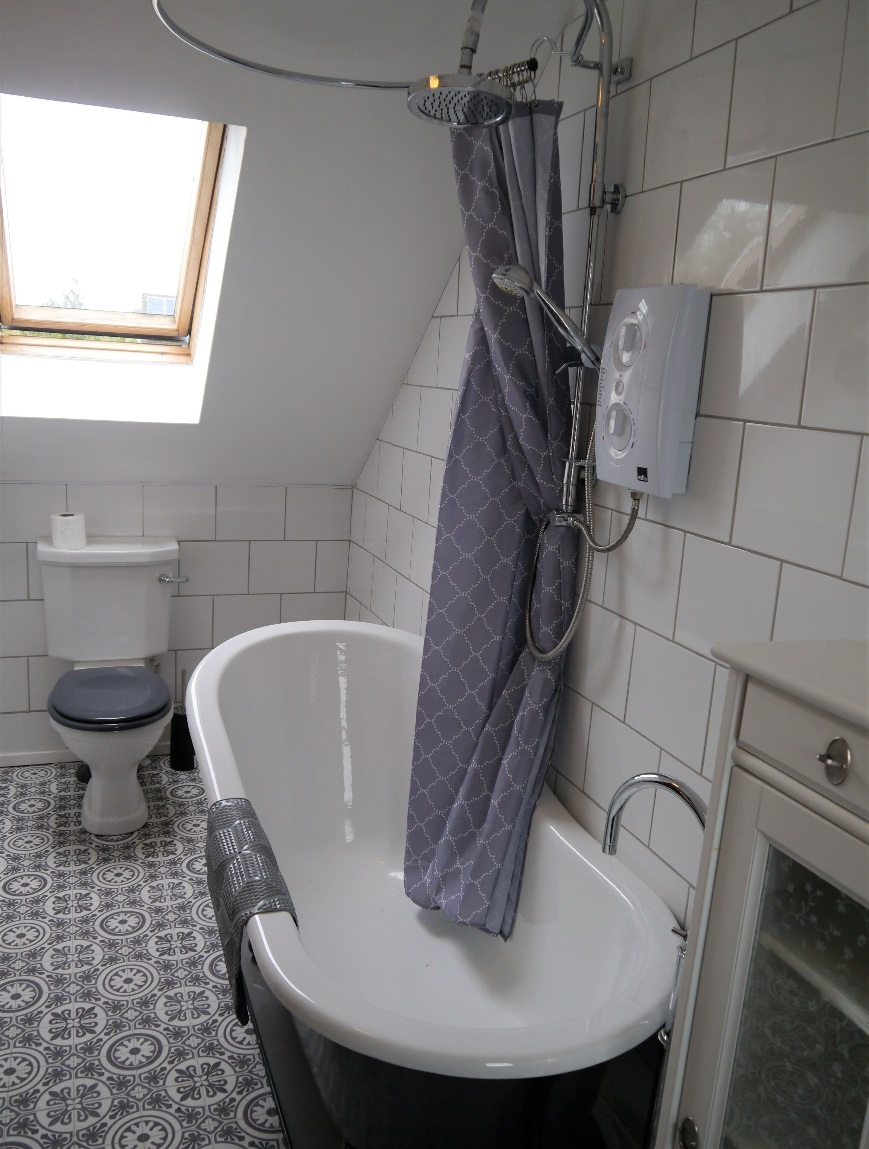 A bathroom with a bathtub, toilet, and shower.