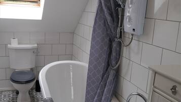 A bathroom with a bathtub, toilet, and shower.