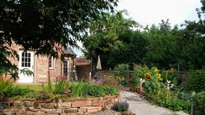 Una casa de piedra con un sendero de jardín que lleva a la entrada.