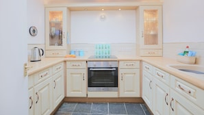 A kitchen with light-colored cabinets, a built-in oven, and a skylight. - Silver Lodge -  a cottage that sleeps 4 guests  in 2 bedrooms (Newton Stewart)