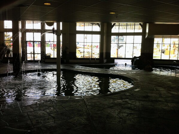 An indoor pool area with large windows, stone flooring, and a central water feature. - Grand Lodge @ Peak 7, Spring Break, Mar 21-28 2026 only, 2 BR condo - sleeps 8 (Breckenridge)