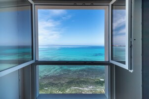 Vista attraverso una finestra su cielo sereno e mare turchese.