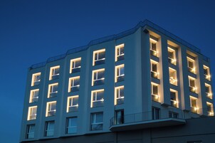 A multi-story building with illuminated windows and a flat roof.