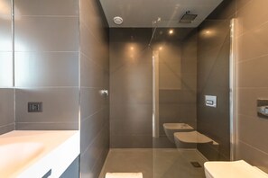 Un baño moderno con ducha de vidrio, inodoro y lavamanos.