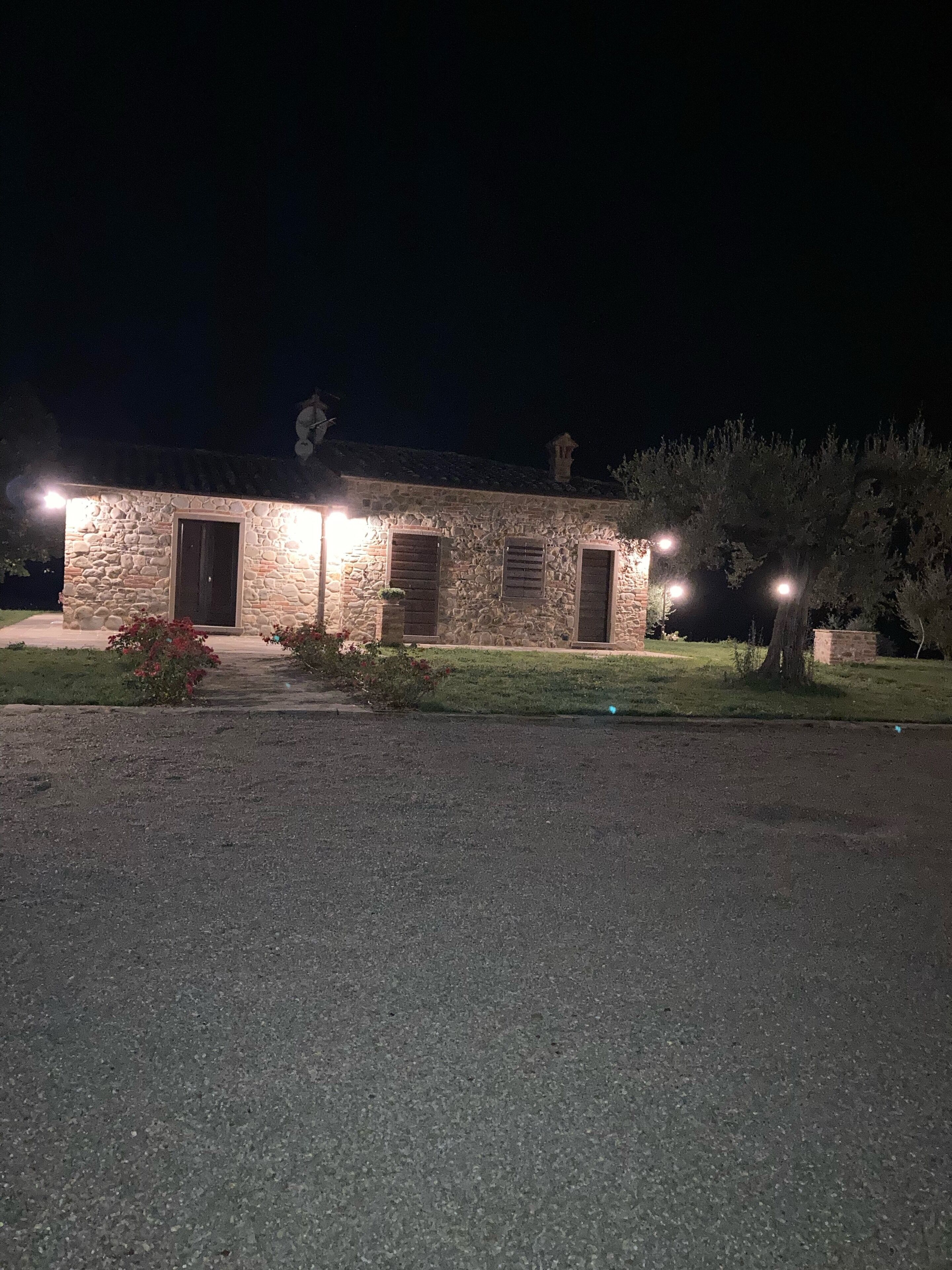 Edifici de pedra amb un carrer empedrat i un jardí ben cuidat.