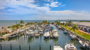 A marina with boats docked, surrounded by palm trees and buildings with balconies. - Amazing Key Largo Tropical Paradise 3/3 Townhouse with Water Lagoon view (Key Largo)