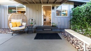 A house with a covered porch, a hanging chair, a small table, and a garden area with rocks and plants. - DreamCatcher-S Uptown! Walk to Shop/Dine/Hike (Sedona)