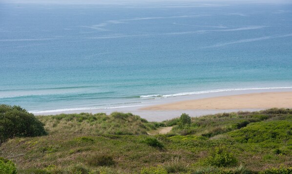 A beach with a sandy shore and a grassy foreground. - Ocean View, The Sands - a house that sleeps 6 guests in 3 bedrooms (Praa Sands)