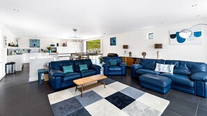 Un salon moderne avec un canapé bleu, une table basse en bois et un tapis noir et blanc.