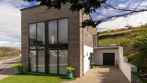 Un bâtiment moderne à deux étages, doté de grandes fenêtres et d’une allée pavée.