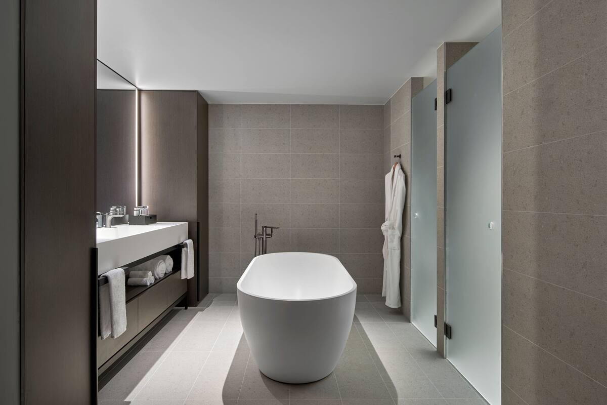 signature suite, 1 king bed, non smoking, city view | bathroom | free toiletries, hair dryer, slippers, towels