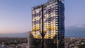 Un hotel alto y moderno con una fachada geométrica distintiva y un letrero que dice "AC BY MARRIOTT".