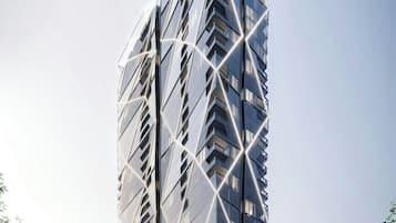 A tall, modern skyscraper with a unique geometric design and reflective glass facade.