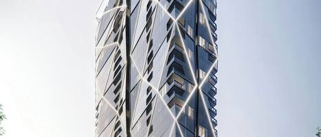 A tall, modern skyscraper with a unique geometric design and reflective glass facade.