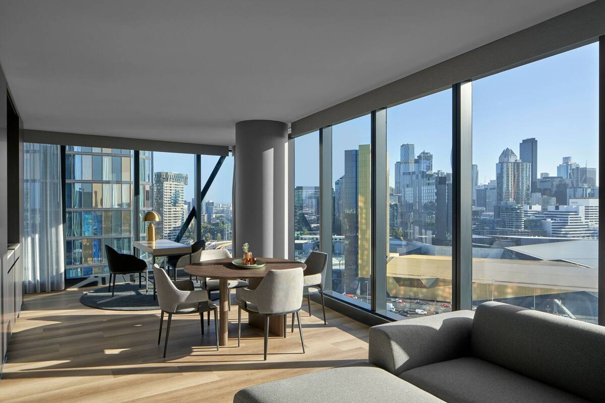 A modern interior with a dining area, large windows, and a city view.