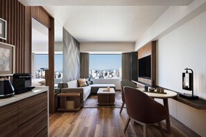 A modern hotel room with a city view, a sofa, a dining area, and a TV. - Courtyard by Marriott Nagoya (Nagoya)