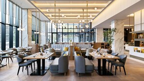 A modern restaurant with high ceilings, large windows, and a variety of seating arrangements including booths and tables.